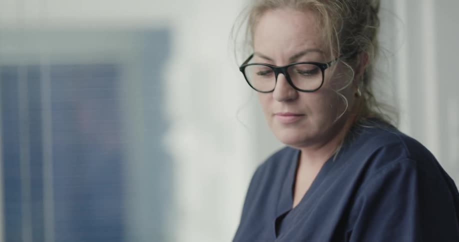 A nurse is in a hospital helping a patient