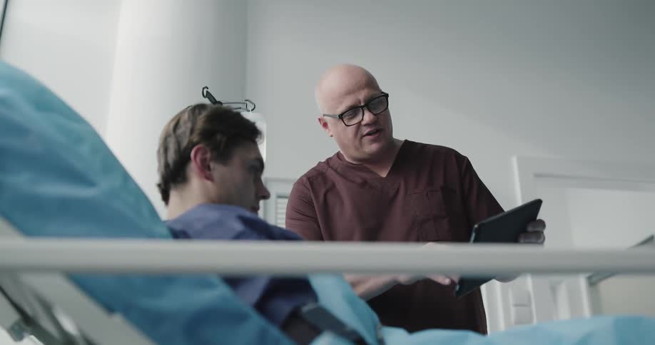 Doctor explaining to a patient on a tablet regarding his procedure