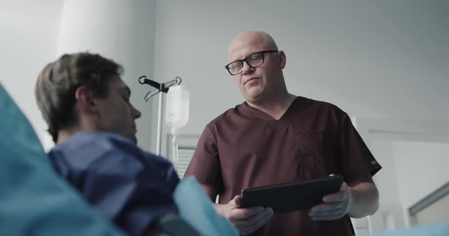 A man talks to a patient in the hospital