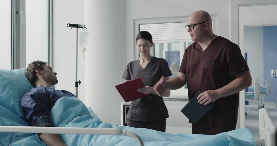 Doctor and nurse talks to patient after surgery
