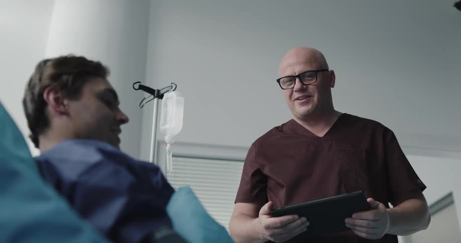 A doctor talks with a patient in the bed
