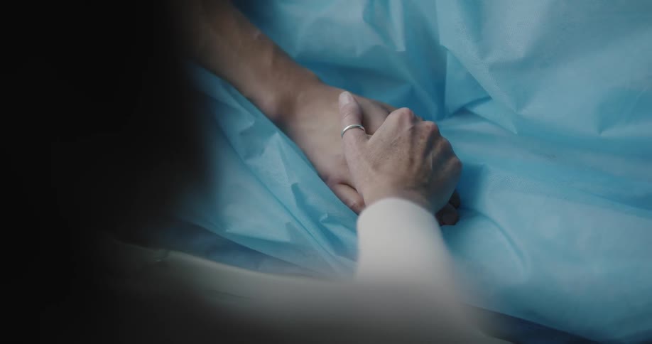 Wife hold her husband hand at the hospal