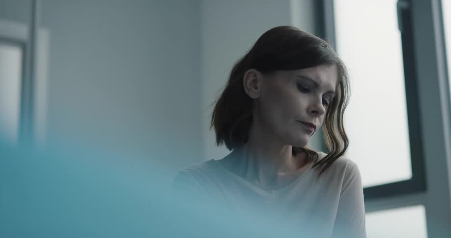 A woman stare blankly to the outside of the window