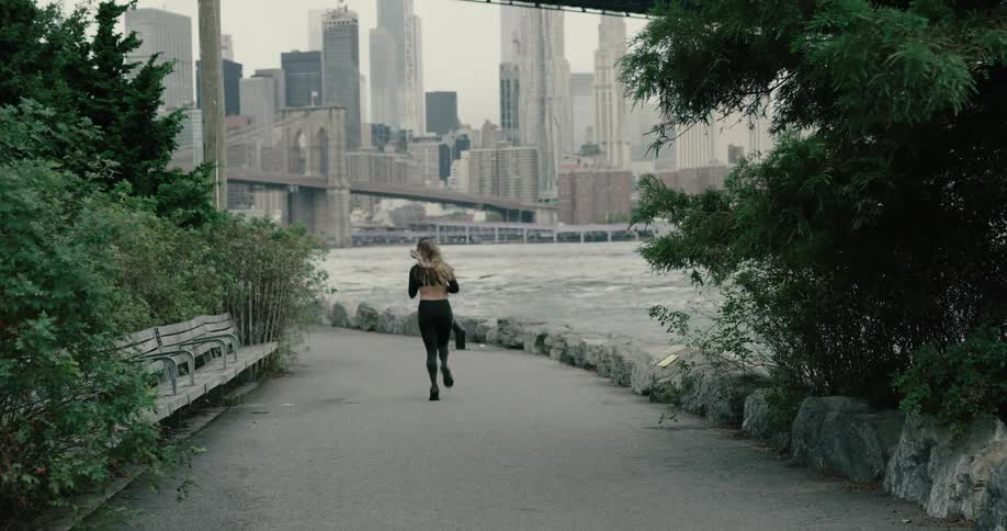 A woman jogs along side the river