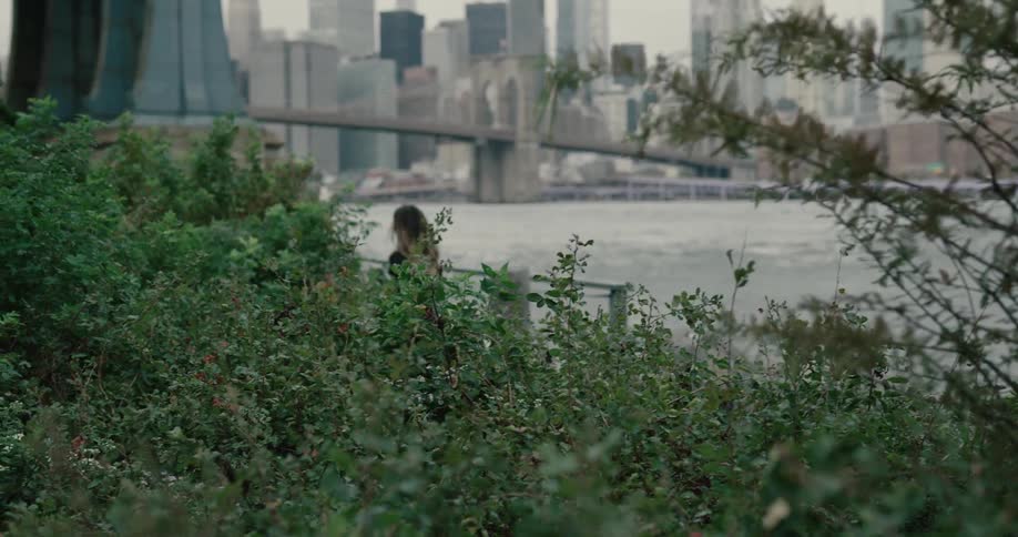 Young woman running on the track near the brooklyn bridge