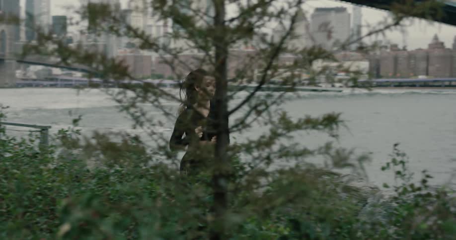 A young woman runs beside the water