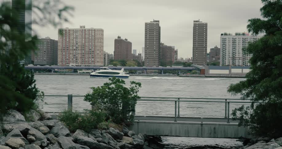 A woman runs on a pedestrian bridge beside a city river