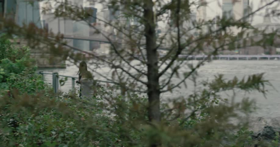 Young woman running on the riverbank on the public park