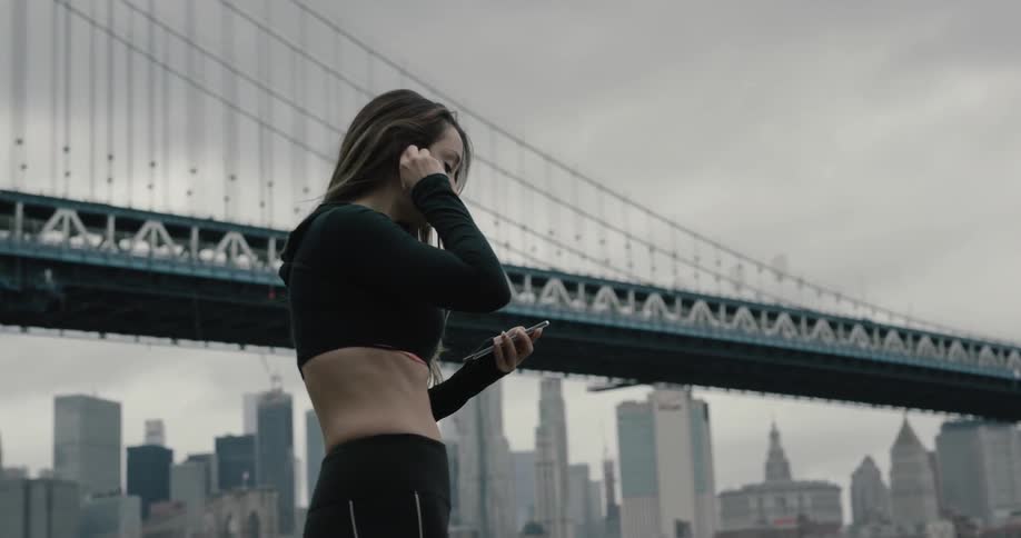 A woman is texting on her phone and jogging