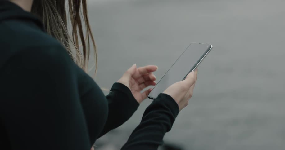 A woman is texting on her phone outdoors