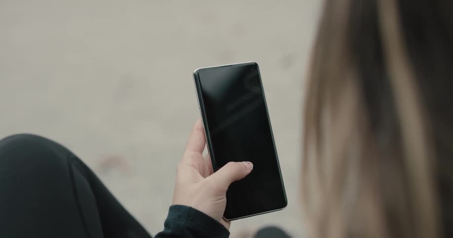 Woman uses smartphone during daylight