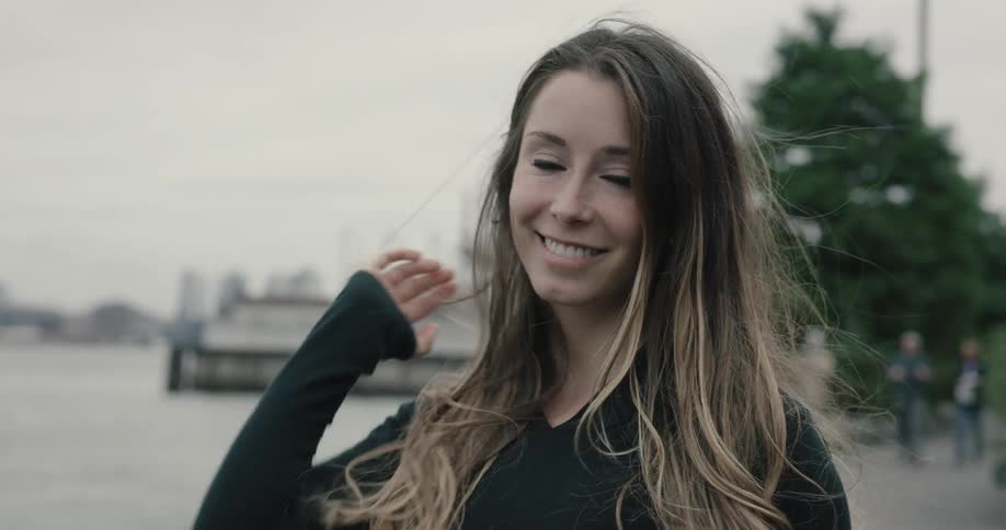 A woman is standing outside and smiling