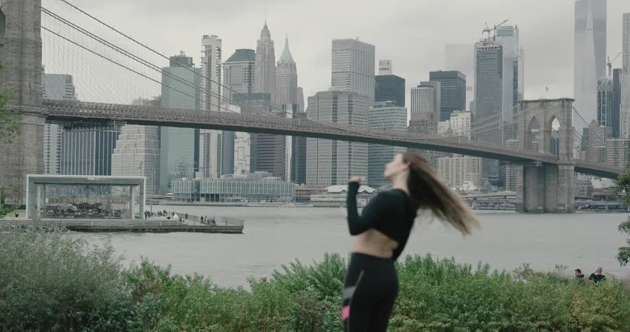 Woman looking at bridge in front of waterfront city