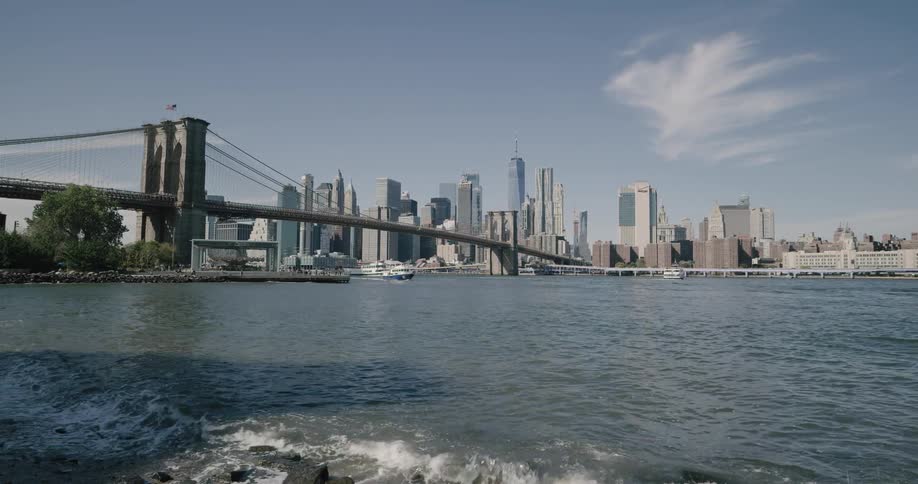 Skyline of the city with tall buildings and bridge next to the sea during daylight