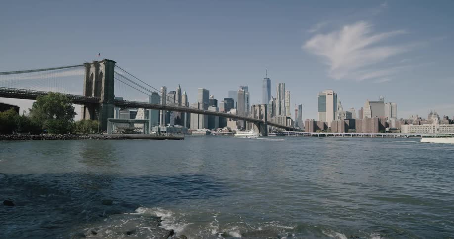 A scenery of brooklyn bridge from the riverbank under the bridge