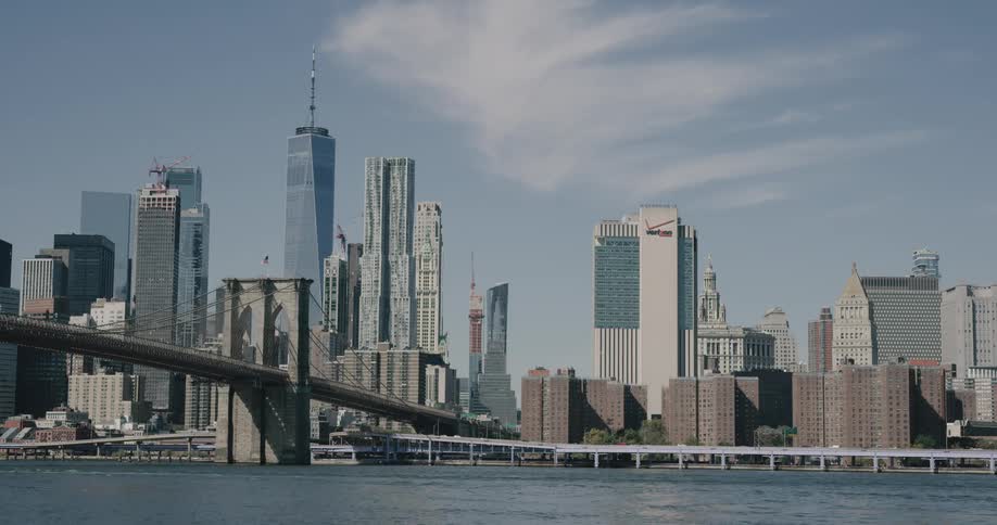 Skyline of the city with tall buildings and bridge next to the sea during daylight