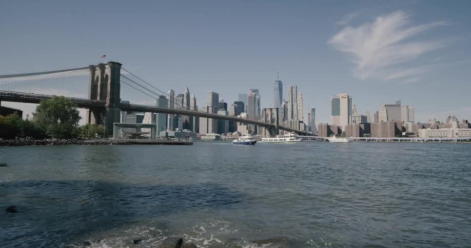 A boat passes under a bridge through the city river