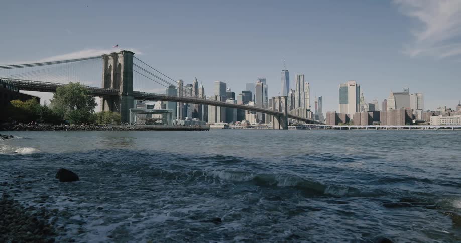 Water hitting the rocky shore outside of a large city skyline