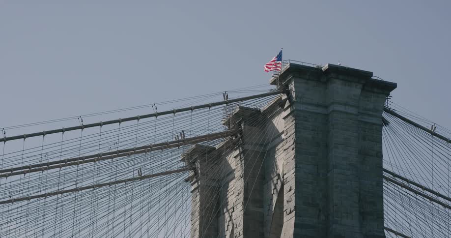 A flag is moving by the wind on top of a structure