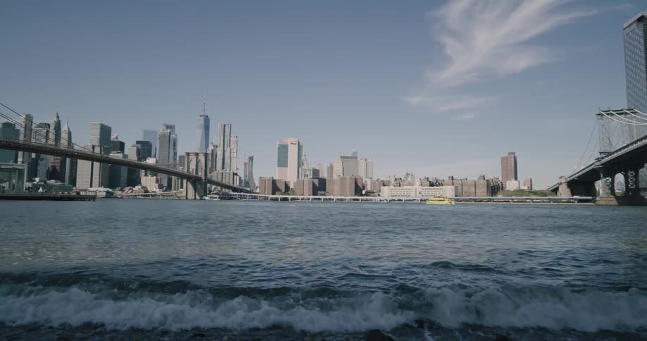 The brooklyn and manhattan bridges leading to new york city skyline across the east river