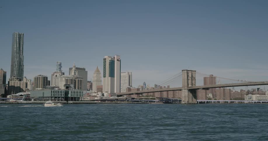 A boat travels in the river towards the bridge