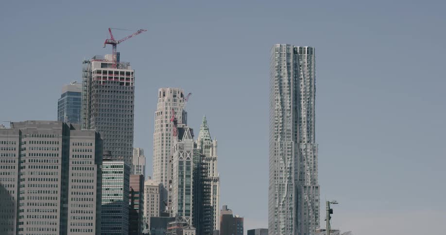 A crane sits atop a skyscraper in an urban area