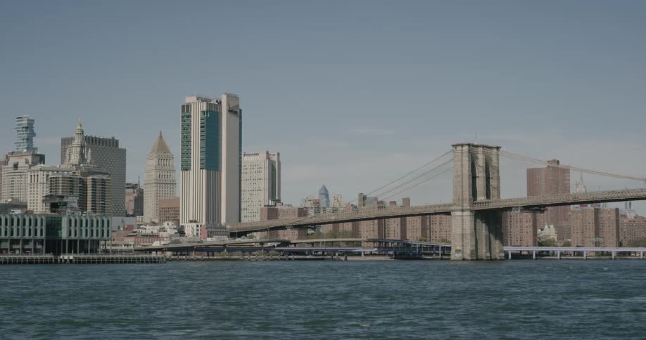 Skyline of the city and bridge over which vehicles go during daylight