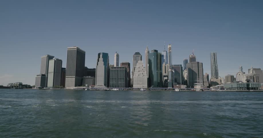 Waves are moving on the coast near a skyline of a downtown city