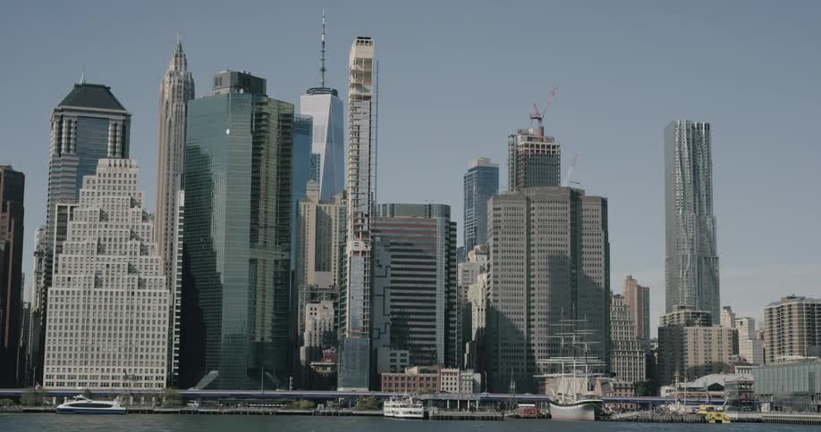 The city is full of tall buildings with cars driving past