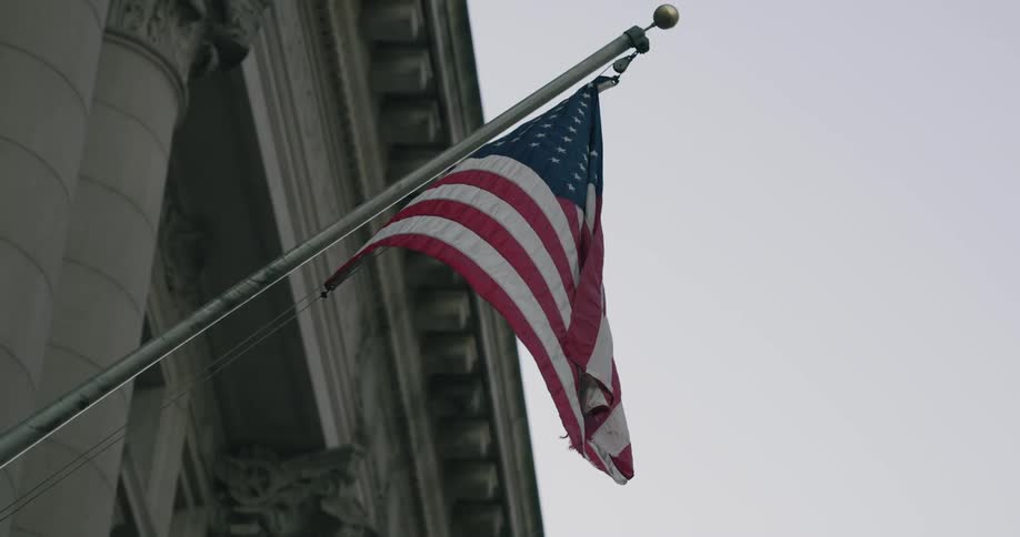 America flag hanging on a government building and blowing in the breeze