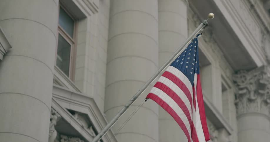 A flag on a stone building blows in the wind