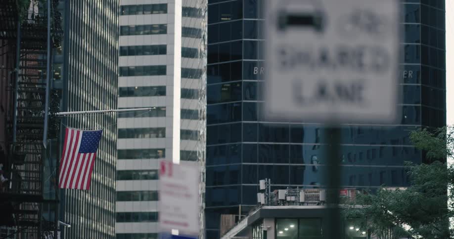 An american flag hangs from a pole in the city