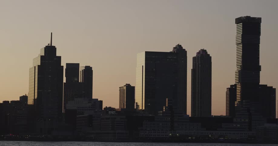 Downtown skyscrapers are silhouettes against sky with afterglow