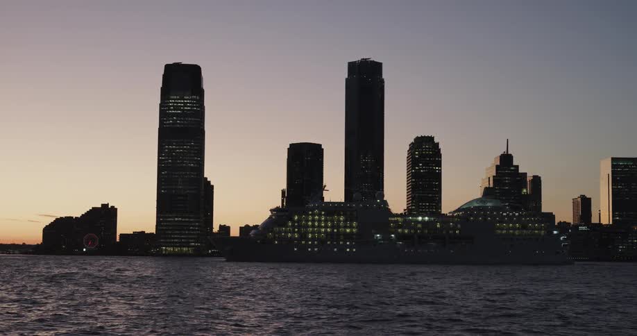 A cruise ship sailing at dawn with skyline background