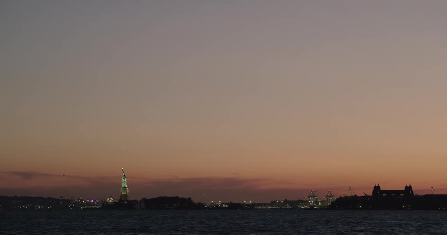 The empire state building in the distance during sunset