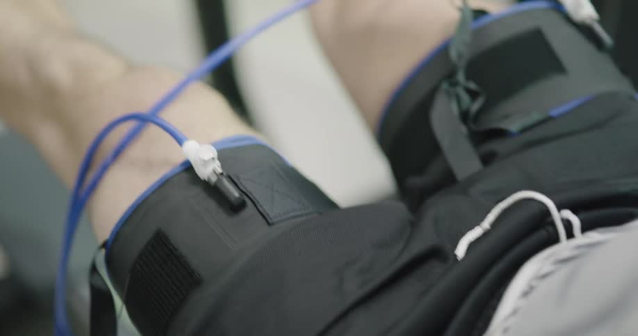 A person doesleg presses with devices attached to their thighs
