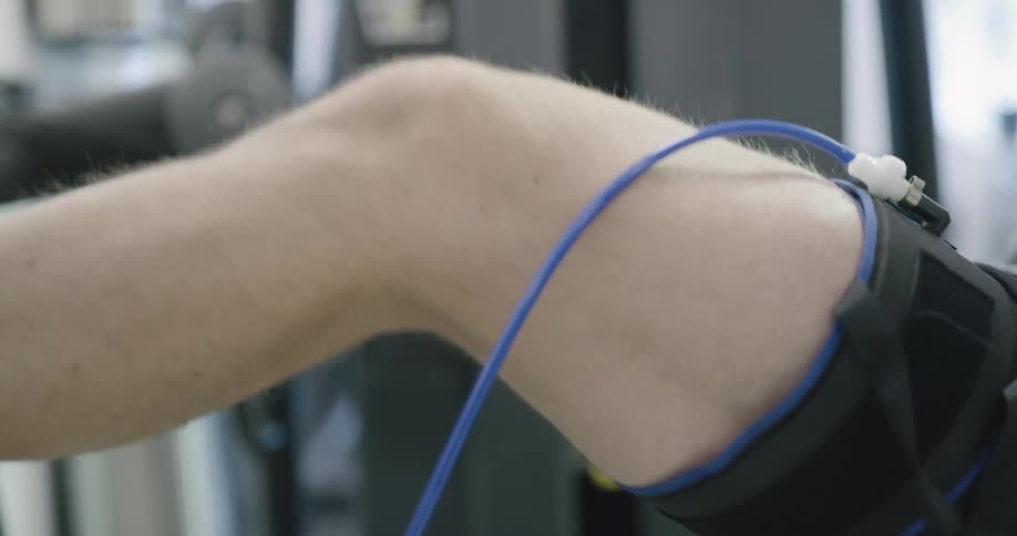 Man with a device on his leg do work out