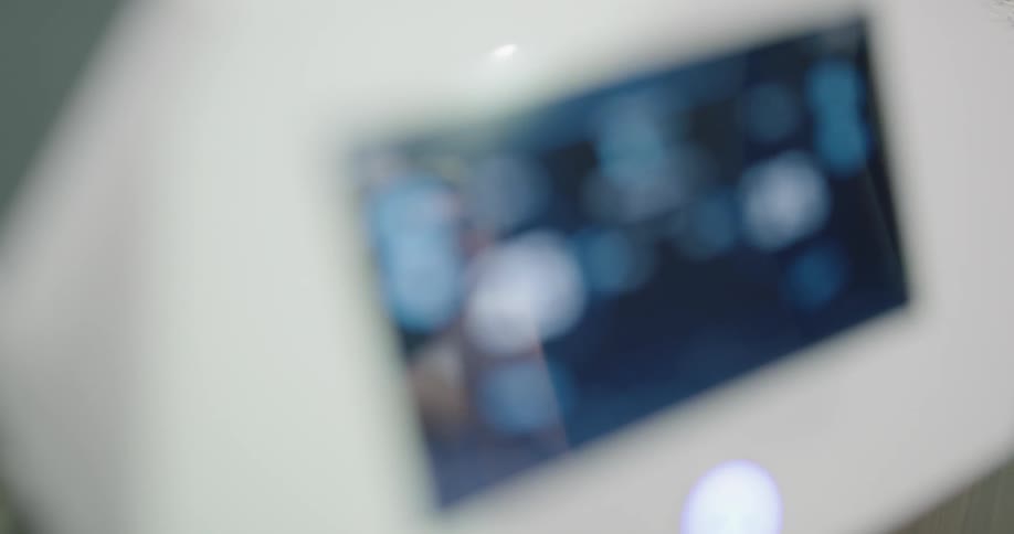 A man does leg stretches while watching his status on a monitor