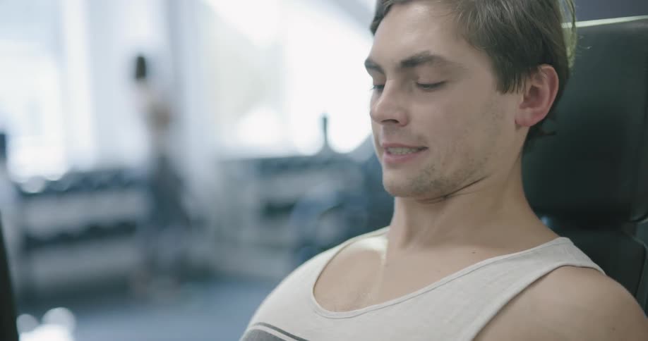 A man is working out on a piece of exercise equipment