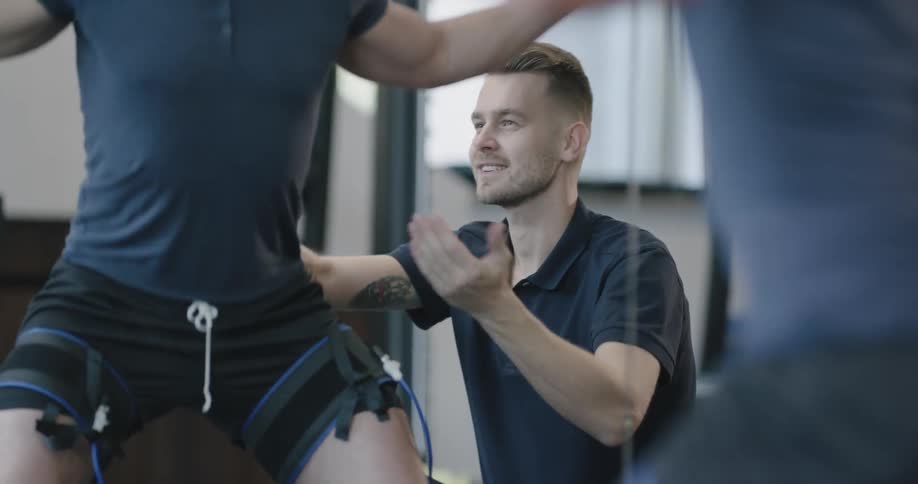 A man lifts weights with a spotter