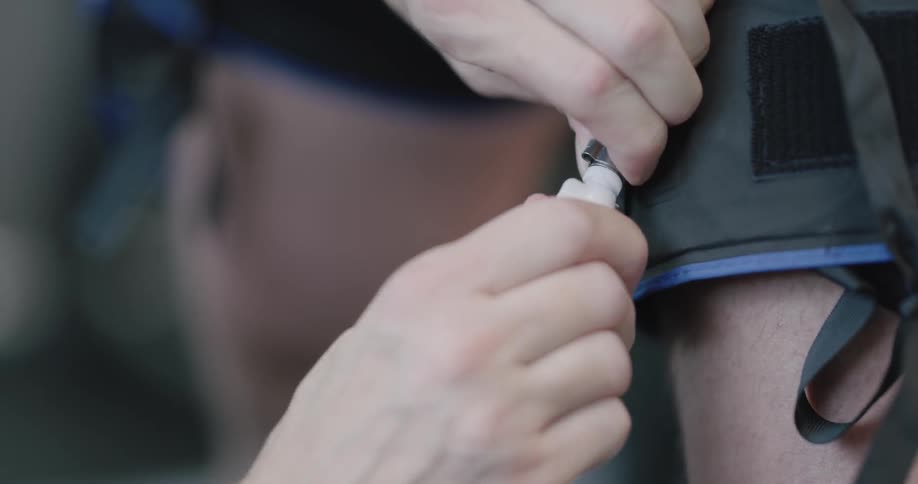 A woman clips a tube on to a blood pressure cuff