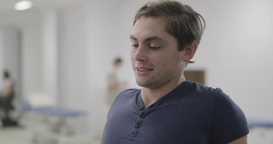 A man strains and exhales deeply while doing physical therapy