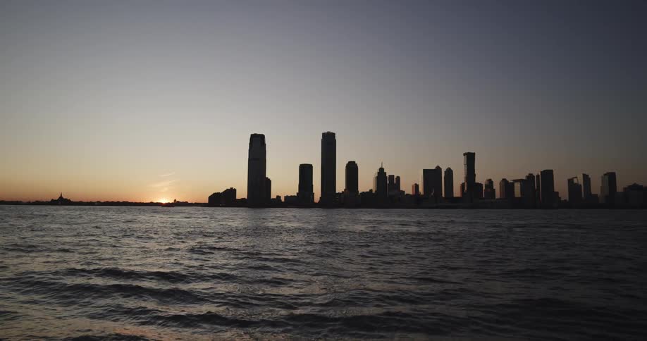 Skyline of the city with tall buildings and skyscrapers at sunset next to the sea