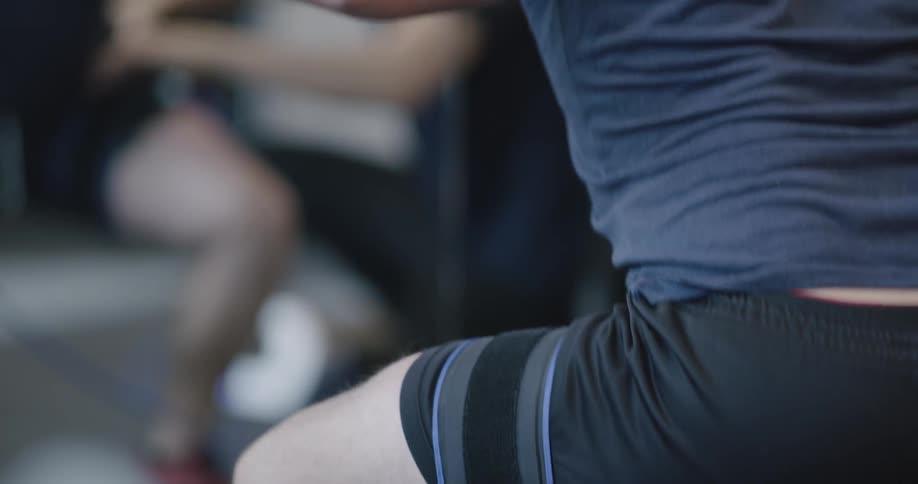 A man squats with a barbell on his back