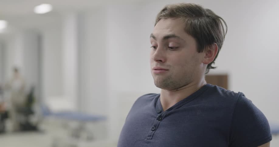 A man leans back and chats while in a gym