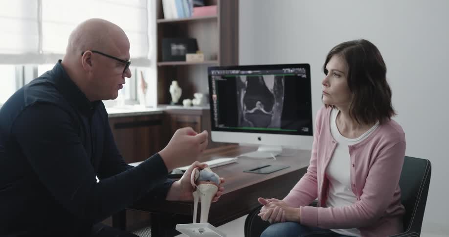 Man and woman talk while sitting at an office desk