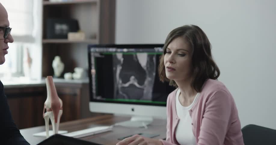 Medical specialist consults with patient in his office