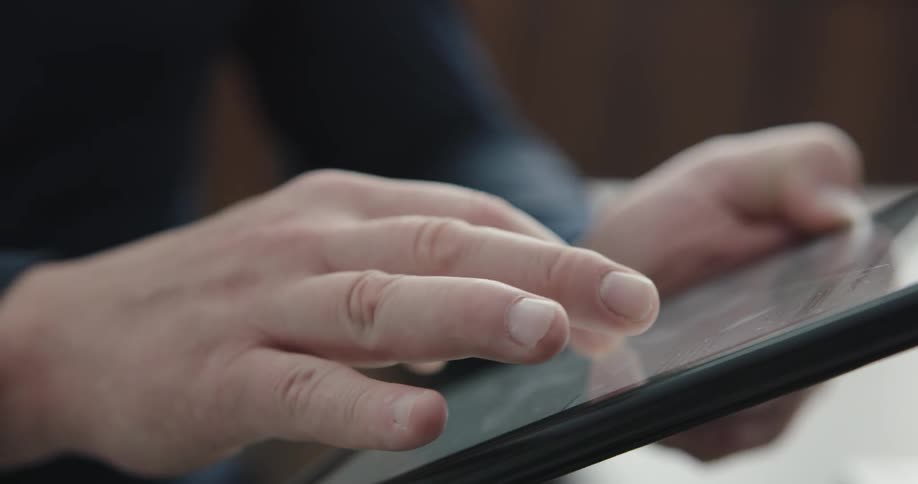 Person scrolls through tablet during the day