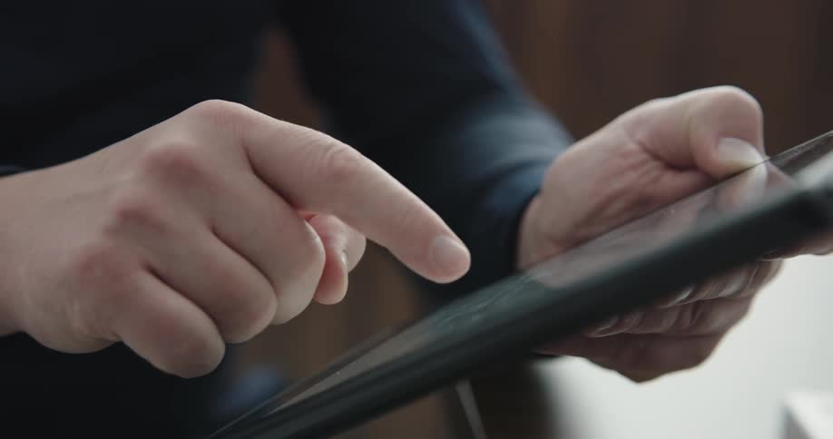 A man uses his right hand to scroll through a smartphone