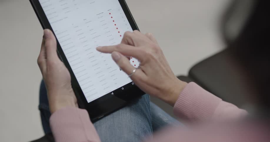 A woman scrolls through text on a tablet
